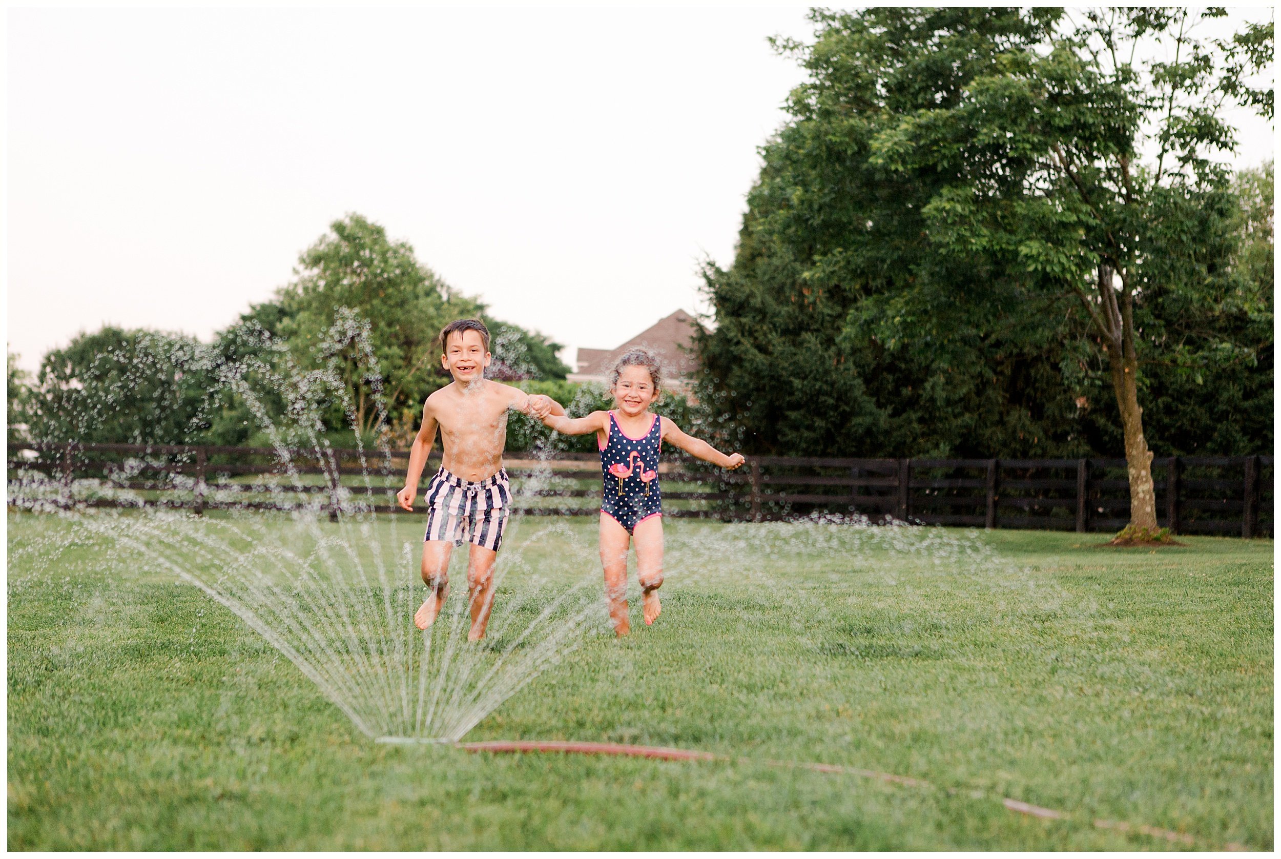  Boy and girl running through sprinklers. Summertime in Kentucky. Family photography by Priscilla Baierlein Photography. 