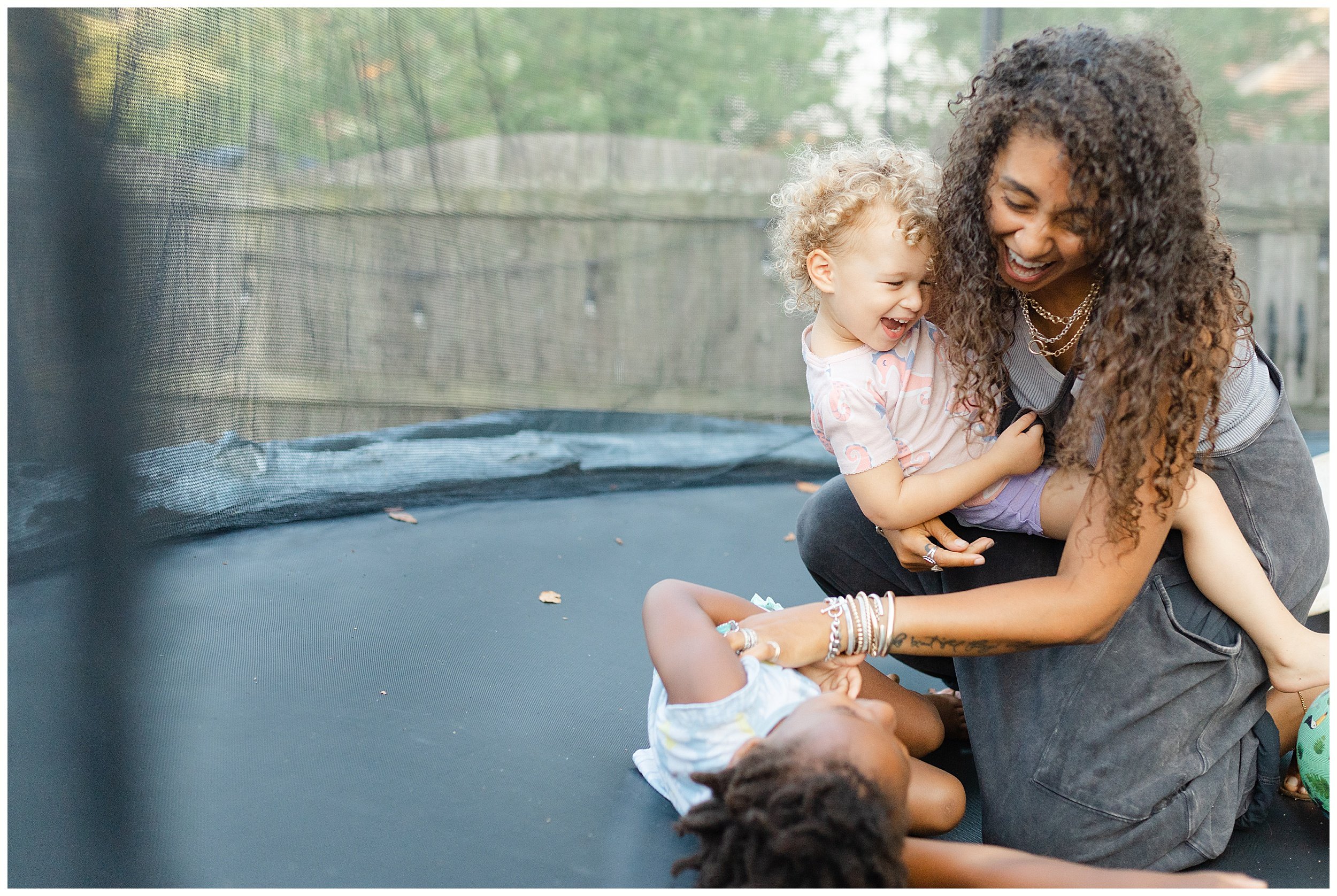  mom playing daughters on trampoline in family photo session in Lexington KY 